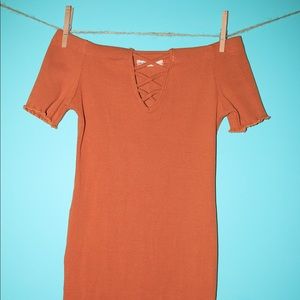 An off the shoulder tan dress